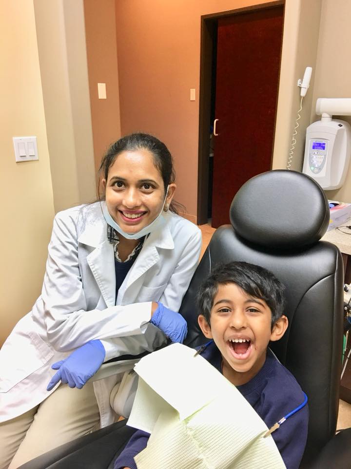 Dr. Suneeta Annamareddy with a happy young patient in the dental chair — kid-friendly pediatric dental visits at Natural Smiles Dentistry, Chandler AZ