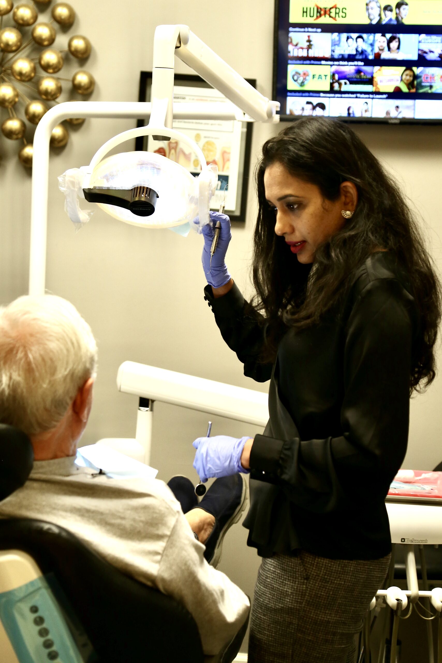 Dr. Reddy reviewing treatment with an older patient relaxed in the operatory chair — sedation dentistry in Chandler / Sun Lakes AZ